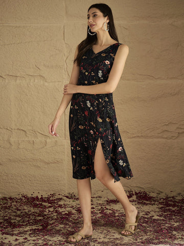 A Sleek Black Floral-Printed Knee-Length Dress With A V-Neckline And Side Slit Sleeveless, Stylish, And Perfect For Effortless Day-To-Evening Charm.